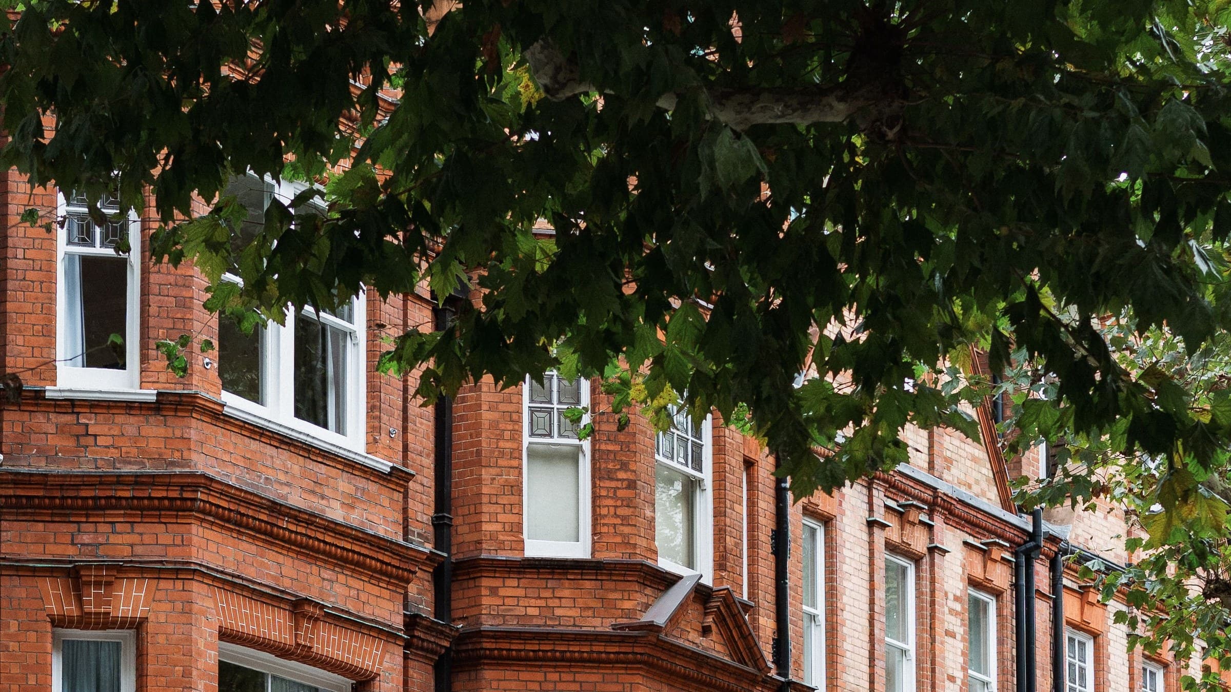 Victorian red-brick British terrace with white sash bay windows